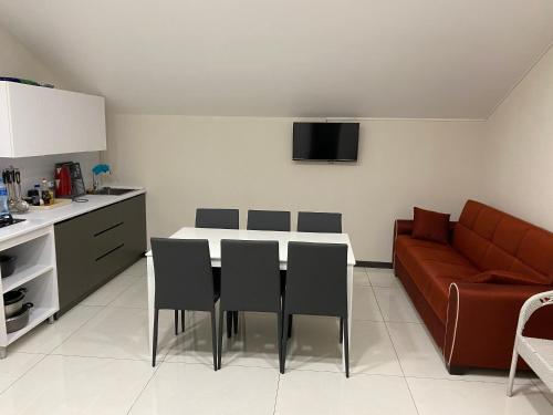 cocina con mesa, sillas y sofá en Banovani SEA, en Ureki