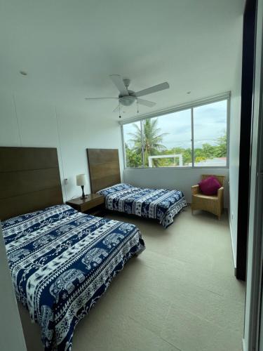 1 dormitorio con 2 camas y ventana en Acogedor apartamento con vista al mar en coveñas, en Coveñas