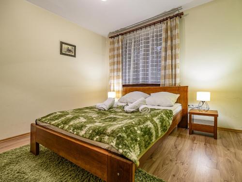 um quarto com uma cama grande e uma janela em VisitZakopane - Crocus Apartment em Zakopane