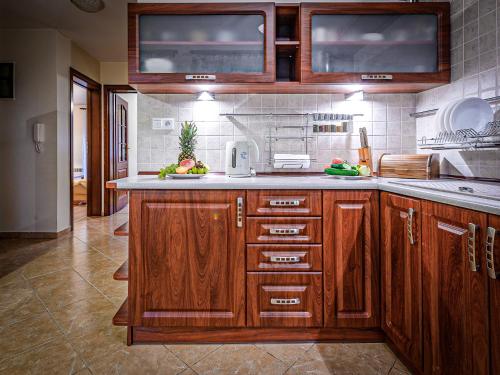 Una cocina con gabinetes de madera y encimera. en VisitZakopane - Crocus Apartment, en Zakopane