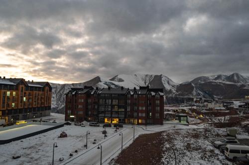 a view of a city with snow covered mountains at New Gudauri Sunny studio in Gudauri