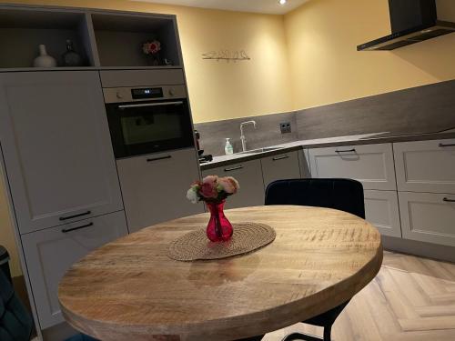 a kitchen with a table with a vase of flowers on it at Bed & Wellness Chinel Luxe vakantiehuis met Sauna's en Bubbelbad in Sint Annaland