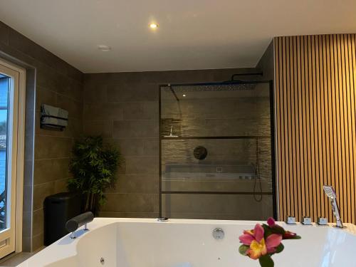 a bathroom with a tub with a flower on it at Bed & Wellness Chinel Luxe vakantiehuis met Sauna's en Bubbelbad in Sint Annaland