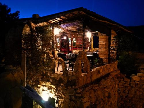 a stone house at night with a table and chairs at Dana Tower Hotel in Dana