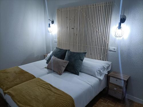 a bedroom with a large white bed with pillows at Luxury Family Homes M in Salamanca