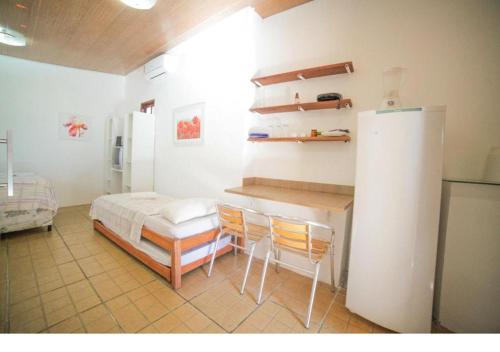 a bedroom with a bed and a table and chairs at Chalé Beija Flor in Praia do Frances