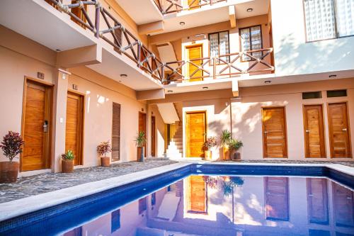 a house with a swimming pool in front of it at Hotel Santa Cruz Punta Zicatela in Puerto Escondido