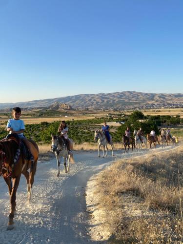 a group of people riding horses down a dirt road at Avanos horse ranch in Avanos