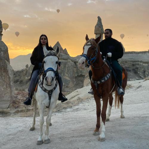 a man and a woman riding horses in the desert at Avanos horse ranch in Avanos