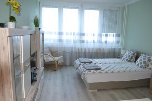 een kleine slaapkamer met een bed en een raam bij Sweet Dreams Apartman in Nyíregyháza