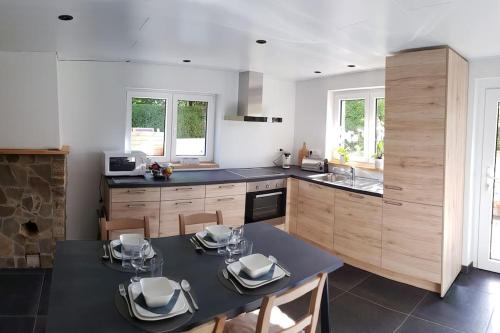a kitchen with a table and chairs in a kitchen at La Maisonnette in Porcheresse