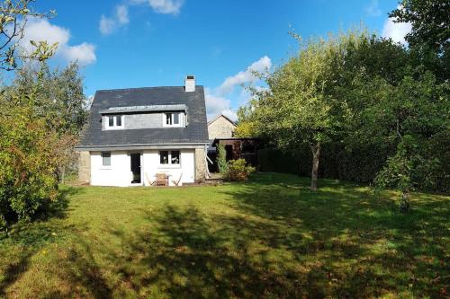 a white house with a yard with trees at La Maisonnette in Porcheresse