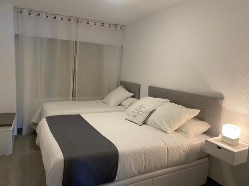 1 dormitorio con 2 camas con sábanas y almohadas blancas en 1a línea con PISCINA Nuevo, en Cullera