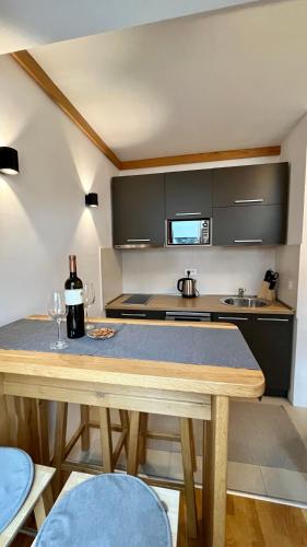 a kitchen with a wooden table with wine glasses at Apartment 533 in Aparthotel Vucko Jahorina - Private host in Jahorina