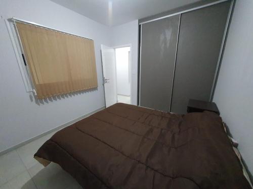 Un dormitorio con una cama grande y una ventana en DEPARTAMENTO AMOBLADO PARQUE SAN VICENTE en Godoy Cruz