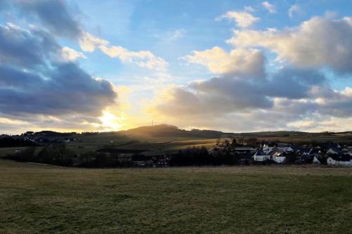 a view of a field with the sun setting at *NEU* Extravagantes Eifelhaus am Nürburgring in Mannebach