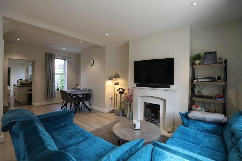 a living room with blue couches and a fireplace at Luxury House Near City Center Hospital &Superstore in Carlisle