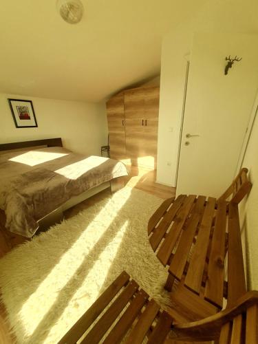 a bedroom with a bed and a wooden bench at Villa Winterfell Popova Shapka in Popova Shapka