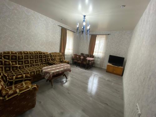 a living room with a couch and a table and a television at Sargsyans guest hause in Bjni