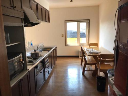 a kitchen with a table and a dining room at Rusutsu Kuma House in Rusutsu