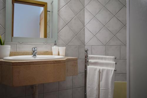 豐沙爾的住宿－Sao Martinho, a Home in Madeira，浴室配有盥洗盆、镜子和毛巾