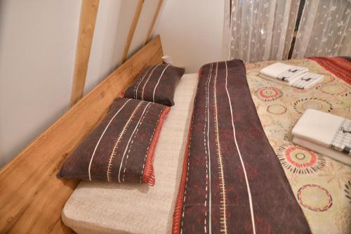 a bed with two pillows on top of it at Brvnara Mont in Zlatibor