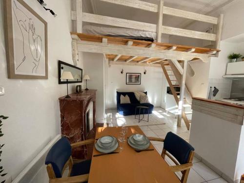 a dining room with a table and a loft bed at Studio la maison dorée à luchon in Luchon