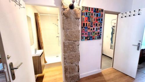 La salle de bains est pourvue d'une douche et d'un mur en pierre. dans l'établissement ZePerfectPlace - Vieux Nice Garibaldi 3 chambres, à Nice