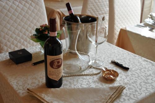 a bottle of wine sitting on a table with glasses at Il Mattino Ha L'Oro In Bocca in Pisa