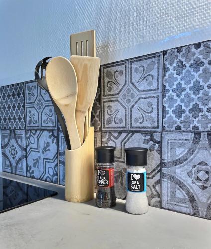 un comptoir de cuisine avec une cuillère en bois et quelques épices dans l'établissement Studio confort Vanves Paris Porte de Versailles, à Vanves