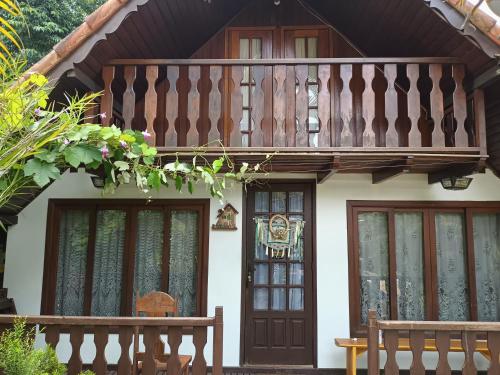 a house with a balcony and two benches in front of it at Hospedaria Bela Vista do Vale in Lumiar