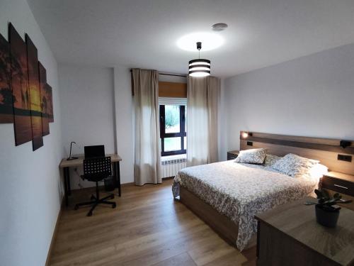 a bedroom with a bed and a desk and a chair at Casa Rigo en Sigüeiro, cerca de Santiago de Compostela in Sigüeiro