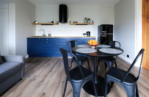 uma cozinha com uma mesa e cadeiras numa cozinha em Sea Zone Apartament przy parku em Wejherowo