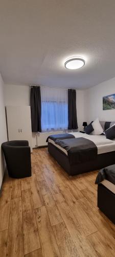 um quarto com uma cama grande e pisos em madeira em Waterfalls Apartment 2 em Triberg