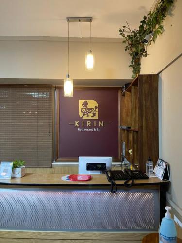 an office desk with a sign on the wall at Kirin Guesthouse and Restaurant in Port Louis