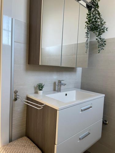 a bathroom with a white sink and a mirror at Cozy Apartment next Outlet Center & Airport with Pool & Garden in Parndorf