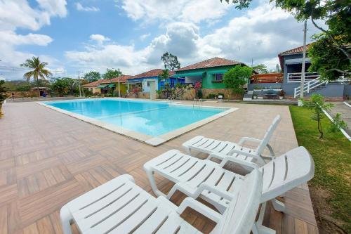 a swimming pool with two lounge chairs next to a house at Lindo Privê 04 Suítes com AR, 5WC e Grande Piscina in Gravatá