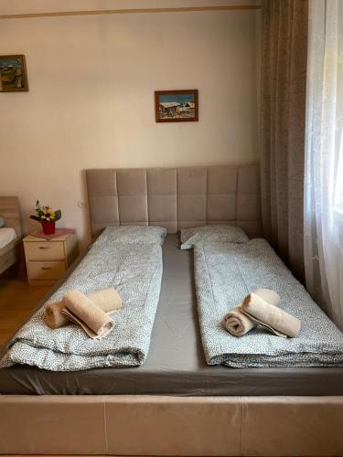 a bed with two towels on top of it at Cheap Outlet Center Apartment with Pool in Parndorf