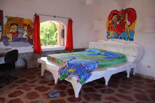 1 dormitorio con 2 camas y ventana en Flintstone cave house, en Poctoy