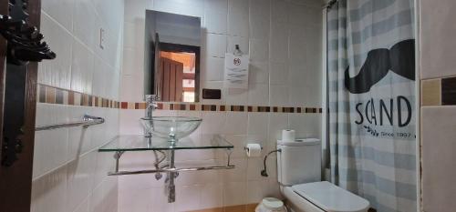 a bathroom with a glass shelf next to a toilet at PATRIMONIO ARABE VISTA A LA ALHAMBRA in Granada