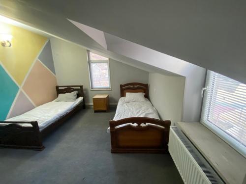 two beds in a room with two windows at Sargsyans guest hause in Bjni