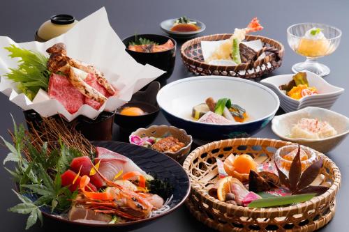 una mesa cubierta con cestas de diferentes tipos de alimentos en たまご肌美人の湯　美榛苑, en Uda