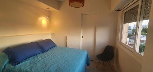 a bedroom with a blue bed and a window at Palermo Panoramic in Buenos Aires