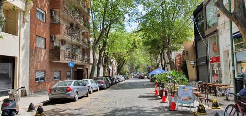 a street with cars parked on the side of the road at Palermo Panoramic in Buenos Aires