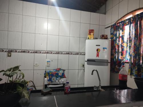 a kitchen with a sink and a white refrigerator at Hostel Raio de Fogo in Paraty