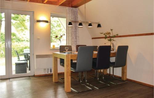 ein Esszimmer mit einem Holztisch und schwarzen Stühlen in der Unterkunft 3 Bedroom Beautiful Home In Gramsbergen in Gramsbergen