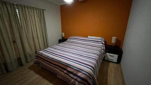 聖弗朗西斯科的住宿－Departamento Céntrico San Francisco，一间卧室配有带条纹毯子的床