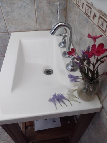 a white sink with a vase of flowers on it at ESPACIO CANELA in Ramallo
