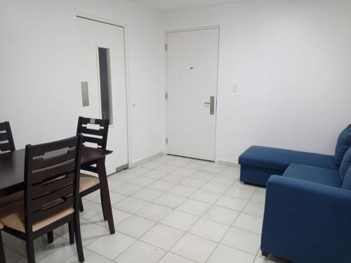 een woonkamer met een tafel en een blauwe bank bij Doña Nancy in Panama-Stad