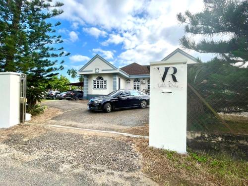 a house with a car parked in a driveway at Villa Ruby - with private swimming pool in Kota Bharu